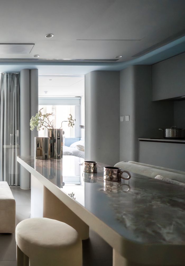 Sophisticated modern kitchen interior featuring a sleek breakfast bar, minimalistic decor, and soft lighting.